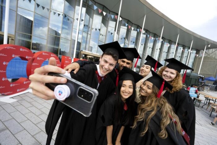 Group of graduates in caps and gowns taking a selfie