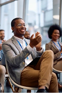 A man applauds in front of a crowd, fostering a positive atmosphere and encouraging others to join in.