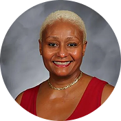 A woman with white hair wearing a red top, smiling and looking directly at the camera.