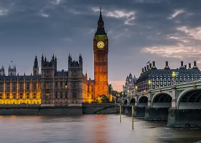 Big Ben and the Houses of Parliament illuminated at dusk, showcasing their iconic architecture against a twilight sky.