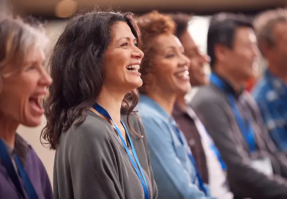 A diverse group of people laughing and smiling together, showcasing joy and camaraderie in a social setting.
