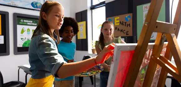A group of children joyfully painting on an easel, showcasing their creativity and collaboration in an art activity.