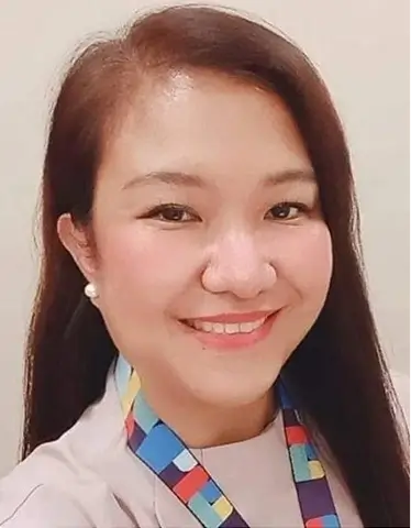 Rowena Padilla with long hair wearing a vibrant, colorful tie, smiling confidently at the camera.