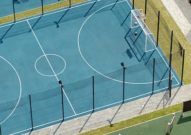 Overhead perspective of a basketball court, showcasing the net, court markings, and surrounding area.