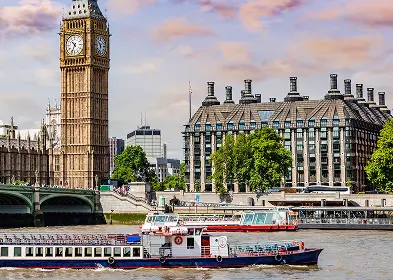 A boat glides down the river with Big Ben prominently visible in the background.